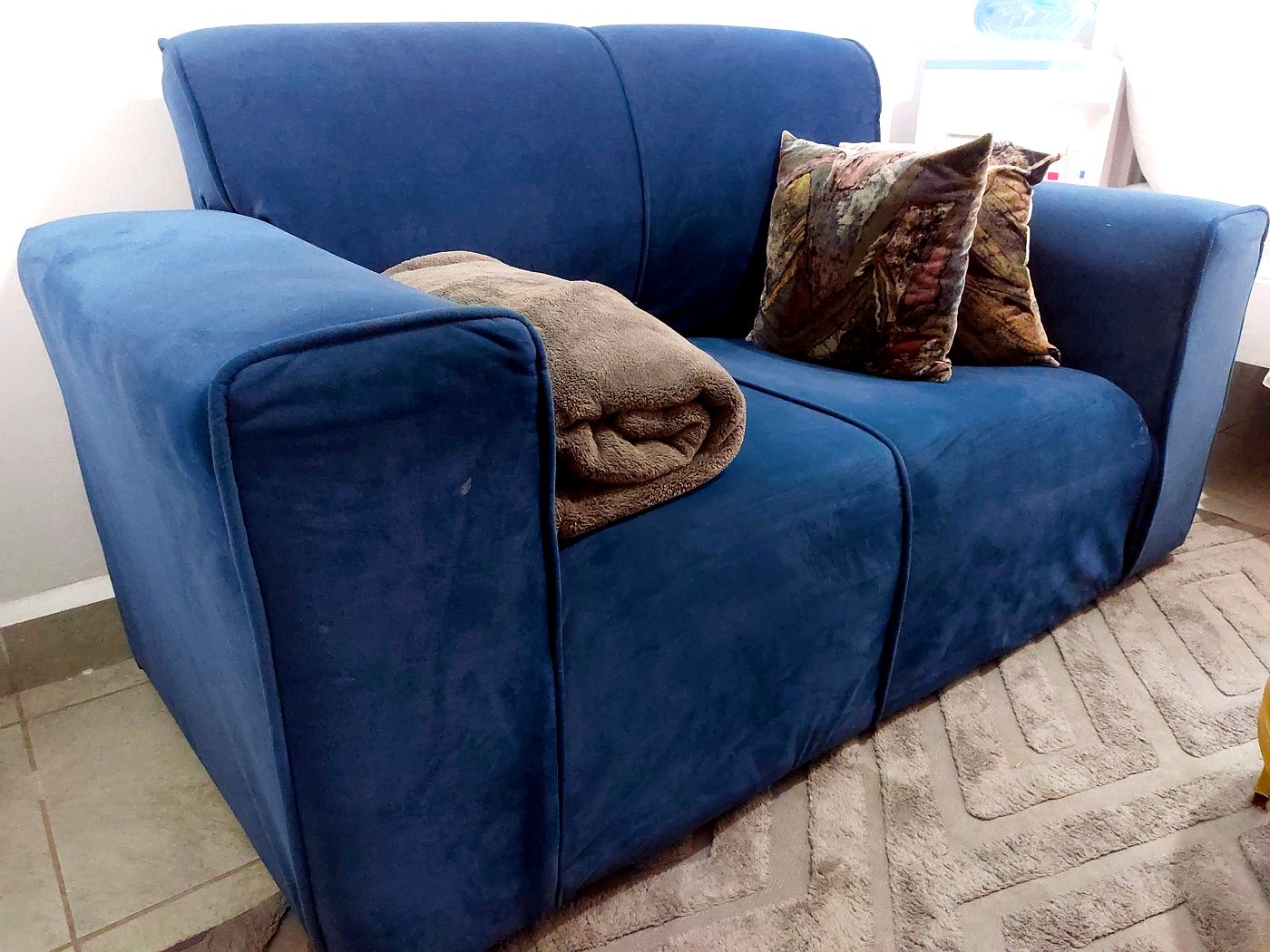 Blue lounge seating with cushions and throw blanket