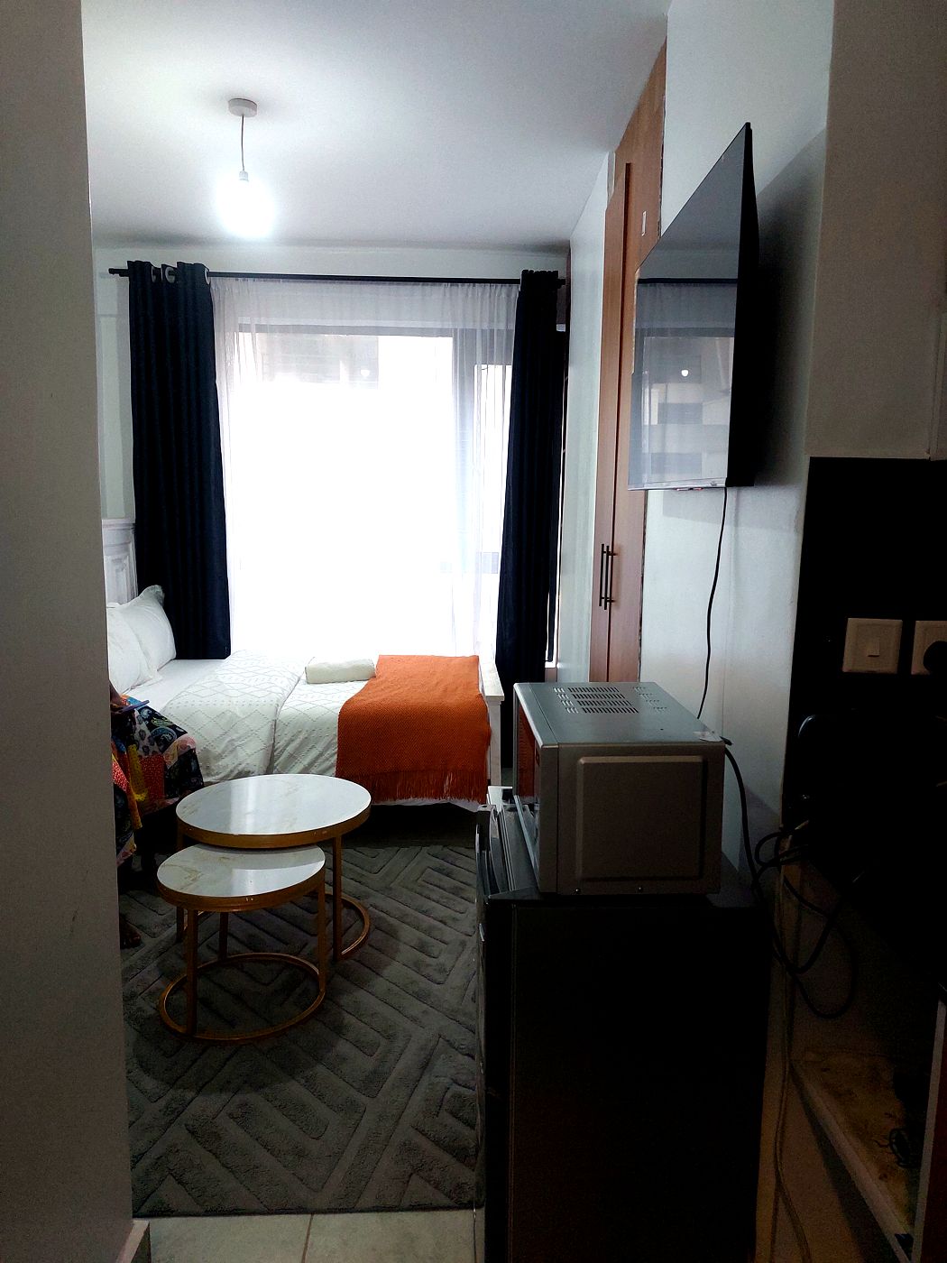 Full studio view with bed, TV and seating area